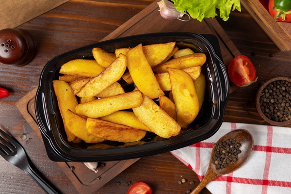 fried potatoes with herbs takeaway in black container - Запеканка с мясом
