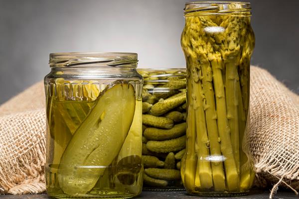 front view of glass jars with pickled asparagus and cucumbers - Мясная солянка