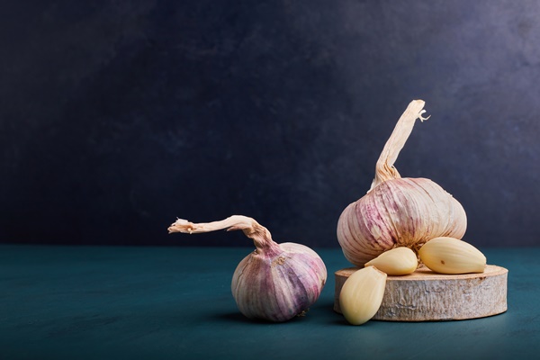 garlic cloves on a piece of wood - Монастырская кухня: суп-пюре морковно-тыквенный, овощи-гриль, салат из красной фасоли с грибами и сухарями