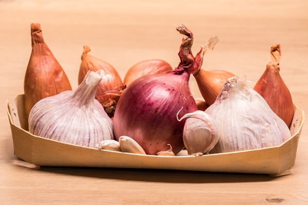 garlic onion shallots in a small wooden basket - Монастырская кухня: луковый суп с редькой, тыквенные оладьи