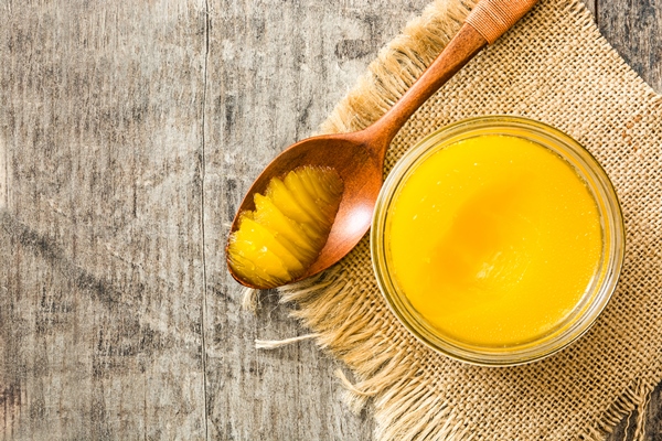 ghee or clarified butter in jar and wooden spoon on wooden table - Баранина, запечённая в духовке