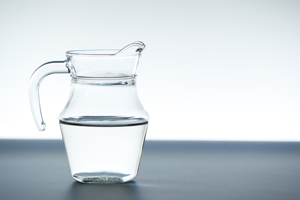 glass jug with mineral water close up - Монастырская кухня: рисовая каша с малиной, пирожное с черносливом