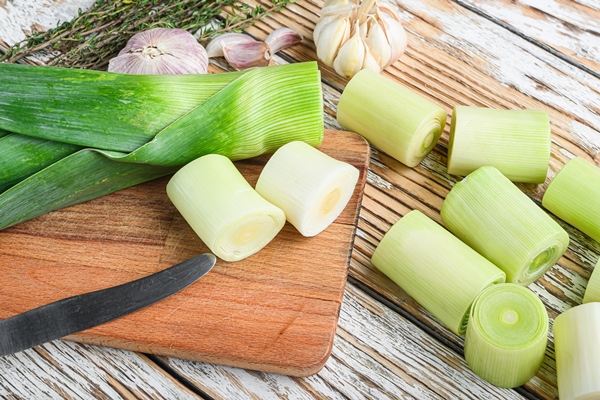 green chopped leek sultan on choppong board over white wood table - Монастырская кухня: смоленская каша с овощами, лимонный кисель