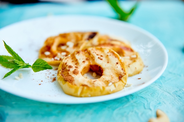 grilled apples with cinamon on white plate - Монастырская кухня: оладьи из картофеля, жареные яблоки и сорбет