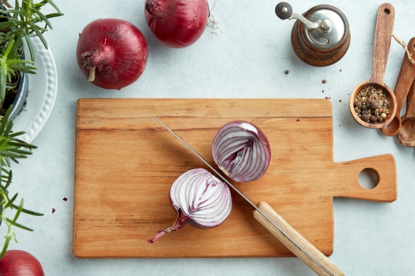 halved red onion on wooden kitchen cutting board top view - Монастырская кухня: архиерейская солянка, постный "Наполеон"