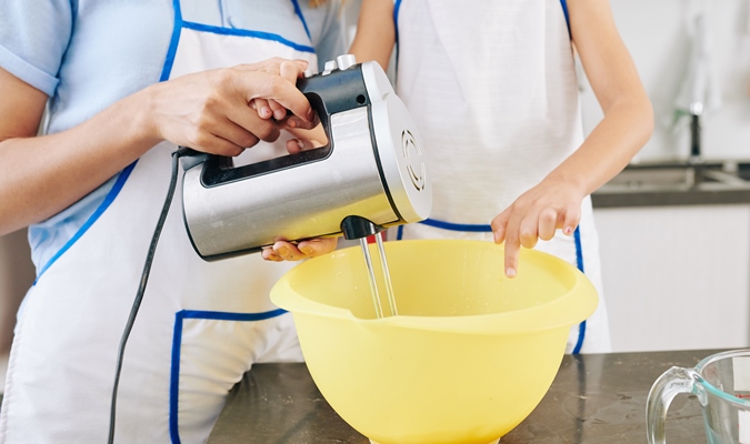 happy little girl and her mother mixing pancake dough in big plastic bowl with electronic mixer 1 - Ванильные панкейки