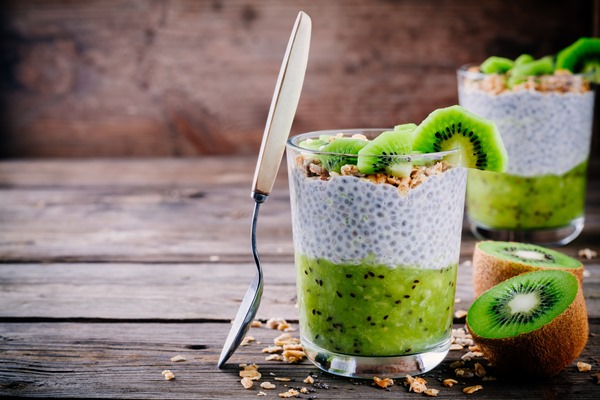 healthy breakfast chia pudding with kiwi and granola in glass on wooden background - Постный чиа-пудинг с киви