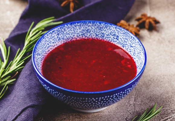 home made spicy sweet sauce from northern forest berries cranberries and apples with rosemary cinnamon and anise stars in blue bowl - Монастырская кухня: оладьи из картофеля, жареные яблоки и сорбет