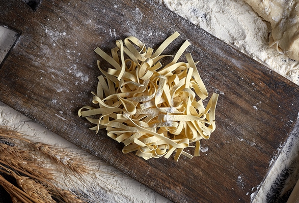 homemade raw noodles made from flour egg on wooden bowl on black 1 - Монастырская кухня: пшённая каша с квашеной капустой, фасолевая лапша