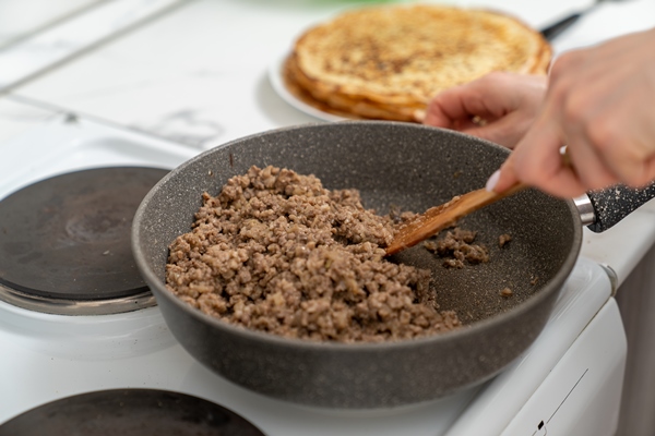meat filling for pancakes is fried in a pan - Блинчики с мясом