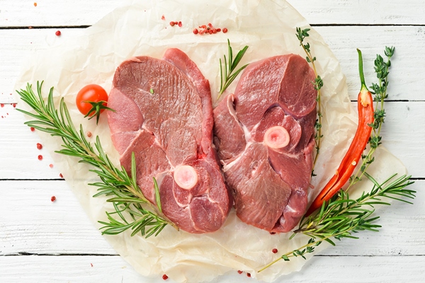meat raw boneless lamb steak with rosemary and spices on a white wooden background top view - Правила приготовления блюд из рубленого мяса