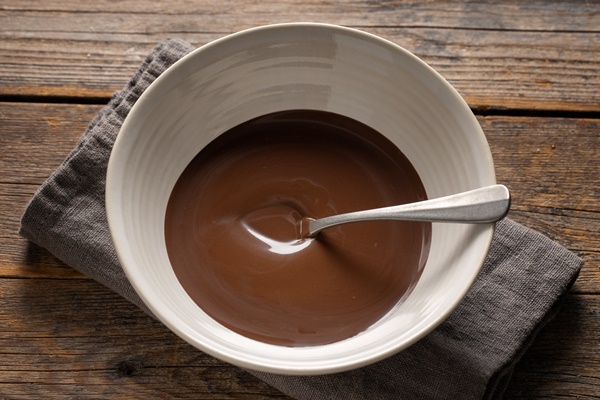 melted chocolate in cup on grey background closeup - Шоколадный соус