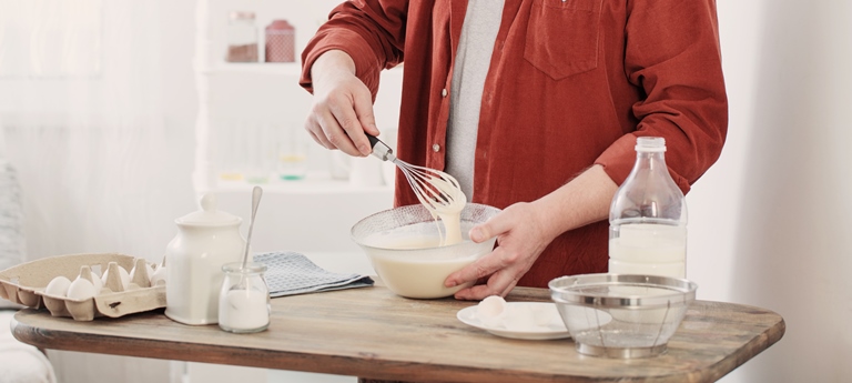middle aged man kneading pancake dough on white kitchen - Панкейки с мускатным орехом