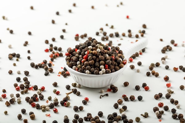 mixed peppercorns in a white scoop side view on spicy and white background - Ростбиф