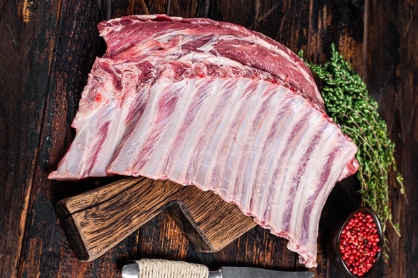 mutton lamb ribs rack on wooden cutting board dark wooden background top view 1 - Баранья грудинка в панировке