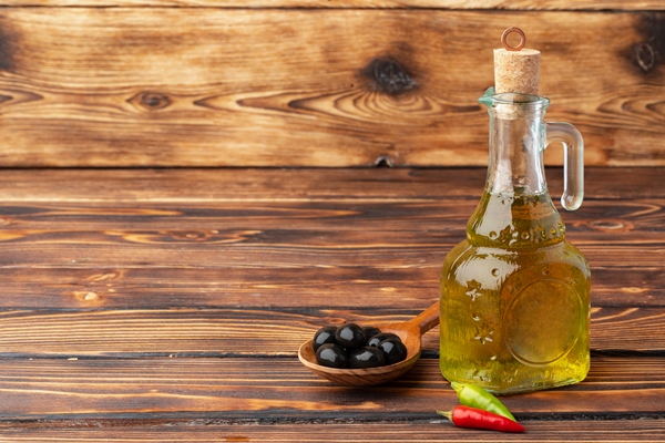 olives and bottle of olive oil on wooden background - Урбеч десертный из тыквенных семечек