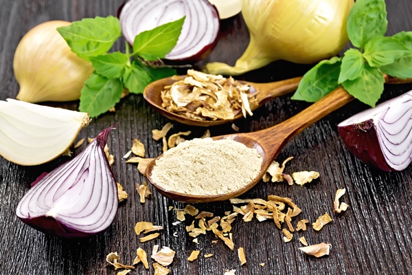 onion powder and dried flakes in two spoons purple and yellow onions fresh basil on wooden board background - Черничный соус без варки