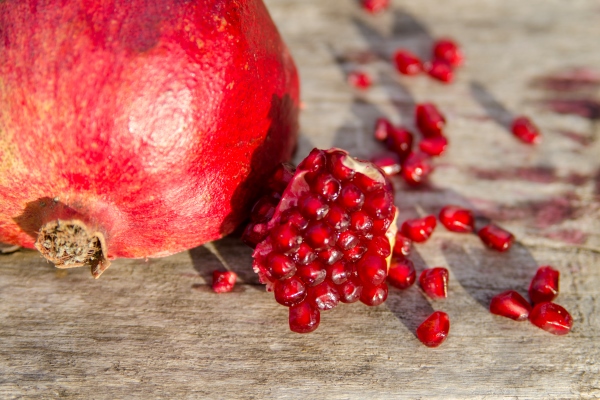 pomegranate fruit and seed on wooden board close up - Грибное сациви