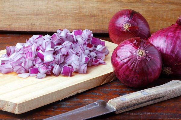 portion of chopped raw red onions over rustic wooden table close up view - Соус фруктово-ягодный