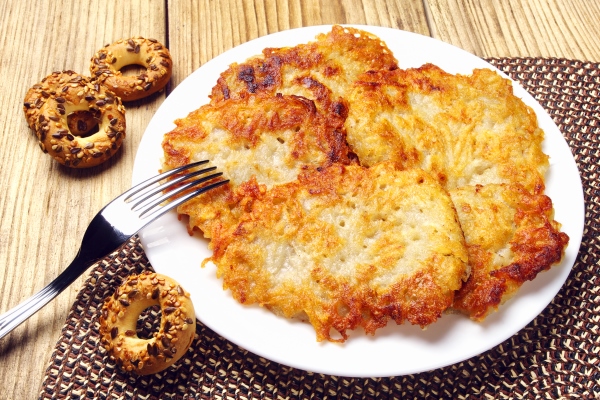 potato pancakes on a plate on a wooden background - Монастырская кухня: оладьи из картофеля, жареные яблоки и сорбет