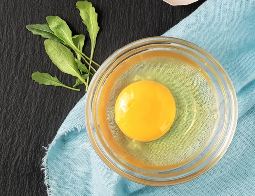raw chicken egg in a glass cup next to eggshells 1 - Блинчики с сёмгой и сливочным сыром