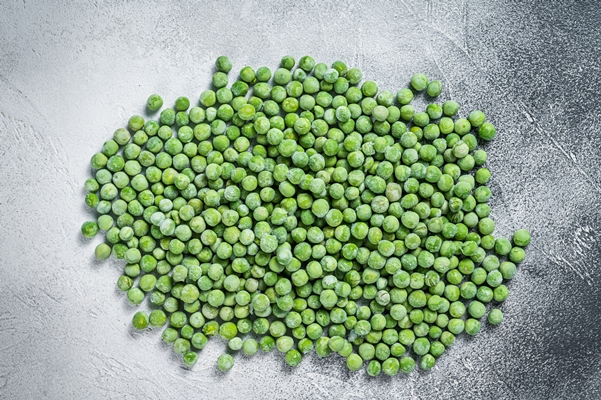 raw frozen green peas on kitchen table white background top view - Монастырская кухня: овсянка с горошком, томатный суп с фасолью
