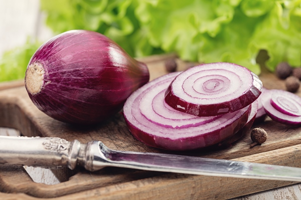 red onion sliced with rings on old kitchen board - Монастырская кухня: картофельный салат, суп рыбный с репой