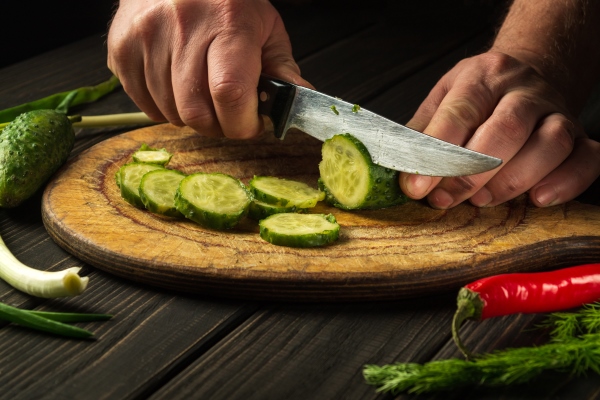 slicing cucumbers on a cutting board delicious salad for breakfast with fresh vegetables - Луковый соус без варки