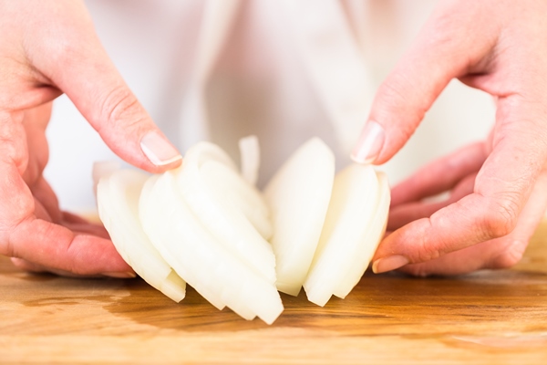 step by step slicing yellow onion with kitchen knife on a cutting board 1 - Монастырская кухня: рисовые тефтели с ржаными хлебцами