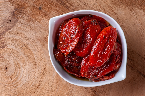 sun dried tomatoes in a white bowl on a woody background - Хумус с вялеными томатами