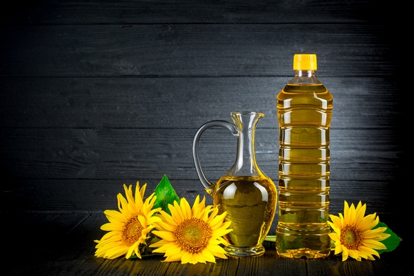 sunflower oil with flowers on black rustic background - Монастырская кухня: овсянка с горошком, томатный суп с фасолью