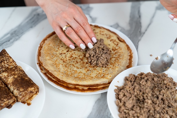 the chef stuffs the pancakes with minced meat - Блинчики с мясом