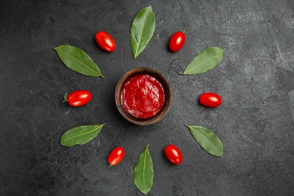 top view a bowl of ketchup around cherry tomatoes and bay leaves on dark ground 1 - Гуляш из субпродуктов