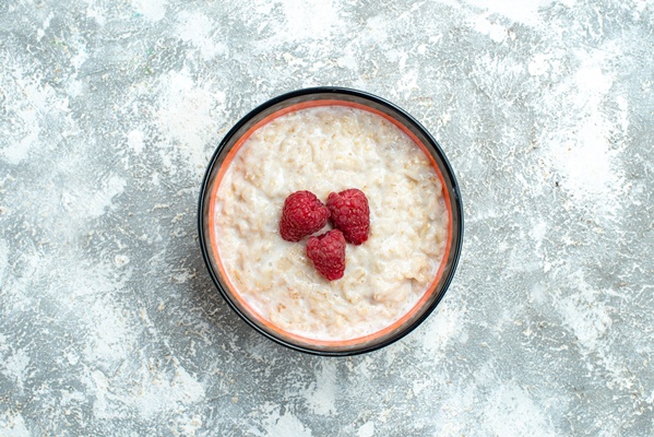top view delicious porridge with raspberries on a light background - Овсянка с бананом без варки