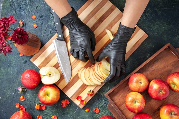 top view female cook cutting apples on a gray surface - Монастырская кухня: пшённые галушки, ореховая тарталетка