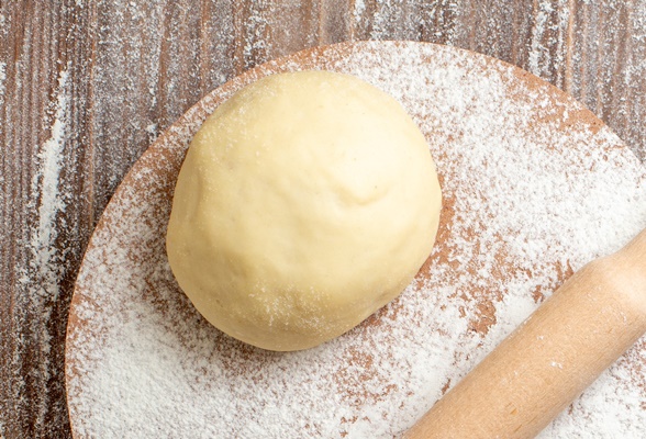 top view raw dough piece with flour on wooden desk meal flour bake dough - Монастырская кухня: пшённые биточки с грибами, жареные пирожки с повидлом
