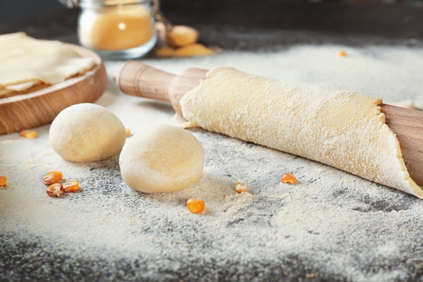 unleavened dough for tortillas with rolling pin on kitchen table - Пресное бездрожжевое тесто