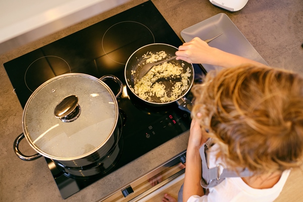unrecognizable person stirring onion in pan on stove top - Монастырская кухня: пшённая каша с квашеной капустой, фасолевая лапша