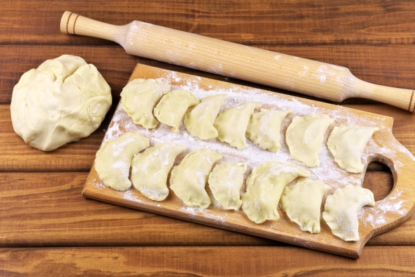 vareniki with potatoes on a cutting board before cooking dumplings on a cutting board - Монастырская кухня: вареники с картошкой, яблоки в тесте