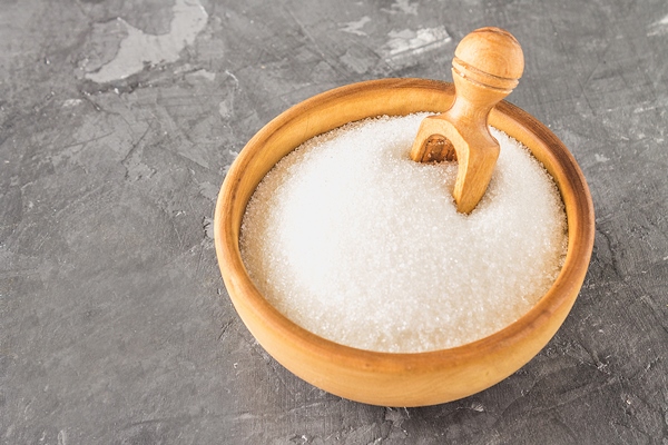 white sugar sugar in a wooden plate with a dustpan on a dark background - Монастырская кухня: рисовая каша с малиной, пирожное с черносливом