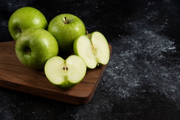 whole and sliced ripe green apples on wooden board - Монастырская кухня: рассольник, постные блинчики с яблоками