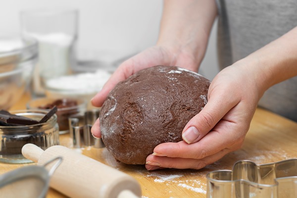 woman hands kneading chocolate dough cooking cookies or dessert cooking at home - Монастырская кухня: драники, постные шоколадные пряники