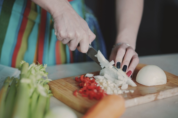 young woman cutting vegetables 1 - Монастырская кухня: суп из кабачков, тёплый салат из чечевицы
