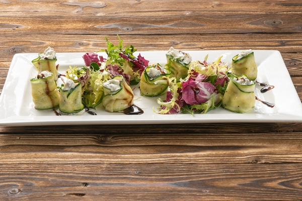 zucchini rolls with ricotta radicchio salad and pine nuts on a white ceramic platter - Монастырская кухня: кабачки с тофу, картофельные вареники с грибами, кукуруза с мёдом