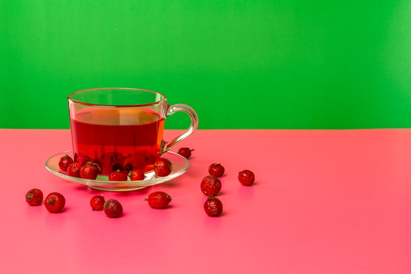 a cup with an infusion of dried rosehip berries on a table with reflection bright background - Особенности питания детей
