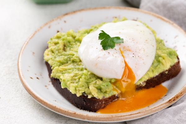 avocado toast on plate with runny poached egg on top and coffee cup - Пюре из сборных овощей