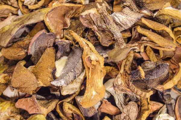 background of dried mushroom on wood table - Начинка из сушёных грибов с рисом и луком