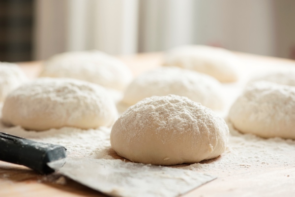 balls of dough covered with wheat flour ready for baking - Тесто для пиццы