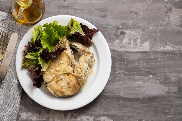 boiled fish with sauce and green salad on white plate - Рыба отварная с чесночным соусом