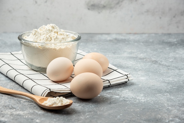 bowl of flour and raw eggs on tablecloth - Кулич быстрого приготовления
